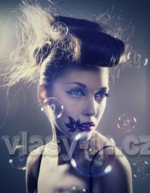 Elegantní vyčesaný účes z dlouhých rovných vlasů šedé barvy, lehce extravagantní